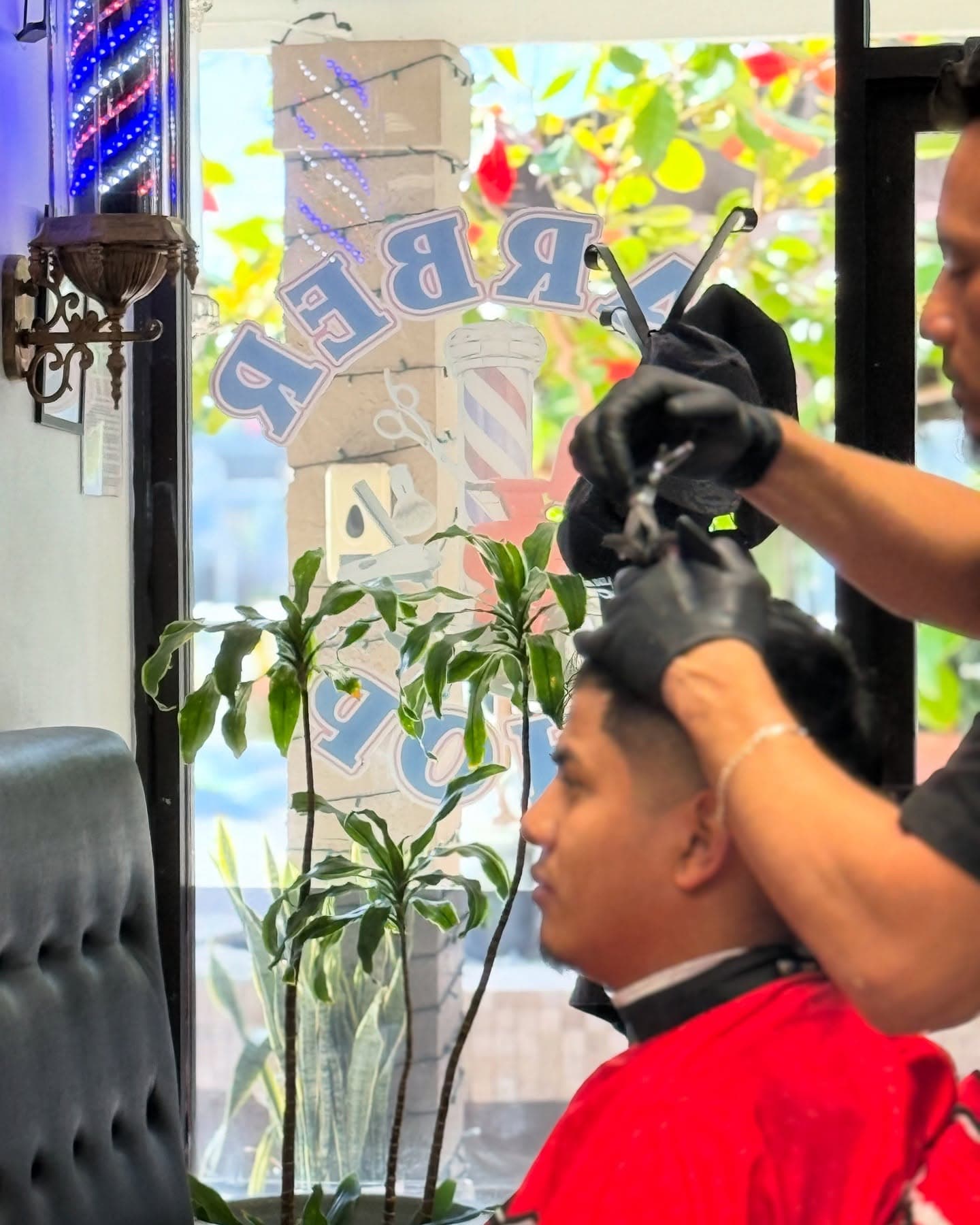 The barber pole in the window at Fresh & Clean Barbershop in North Palm Beach