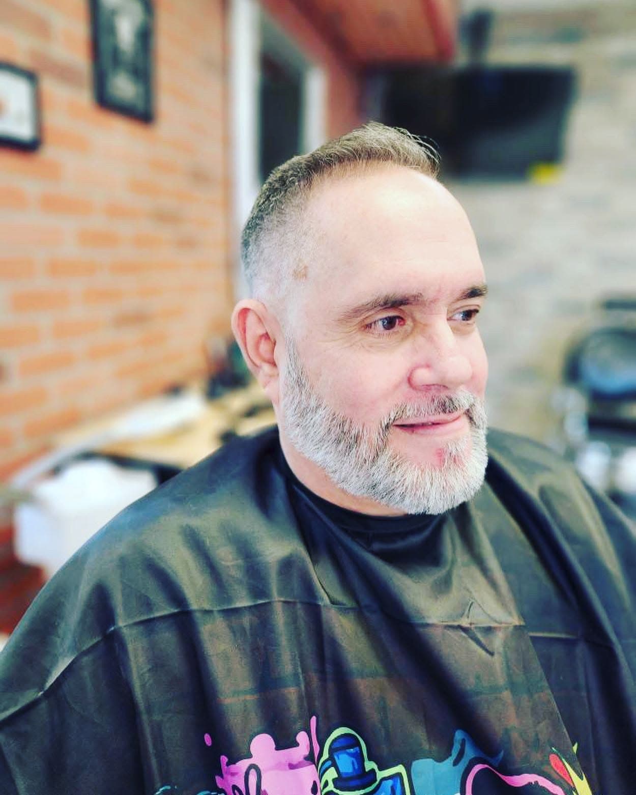 A regular with a clean gray cut and beard